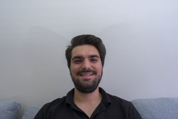 一个英俊快乐的年轻人的肖像，微笑着看着相机图片下载