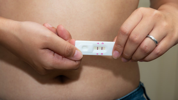 近距离观察一名阳性孕妇手中一名怀孕少女的腹部背景图片下载