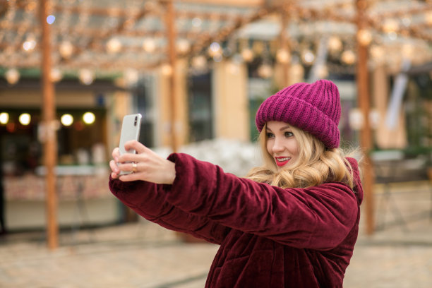 迷人的年轻女子有乐趣，并在基辅花环的背景下自拍图片下载