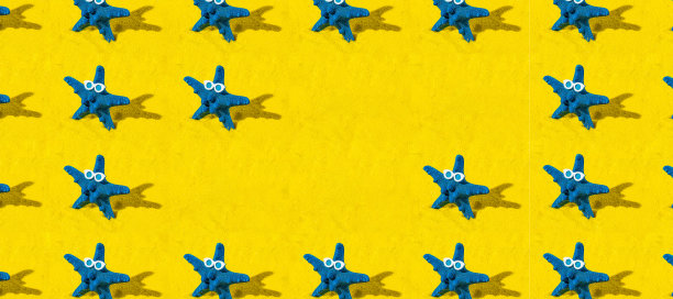 创意图案背景与蓝色海星与太阳镜在黄色的沙子。极具创意的夏季或假期概念与复制空间。图片下载