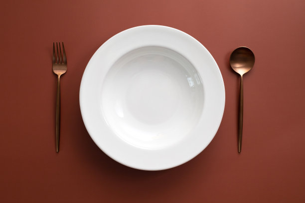 空的白色盘子映衬着棕色的背景图片下载