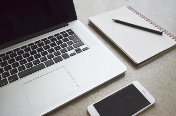 笔记本电脑，智能手机，笔记本，铅笔放在现代的混凝土桌上图片下载