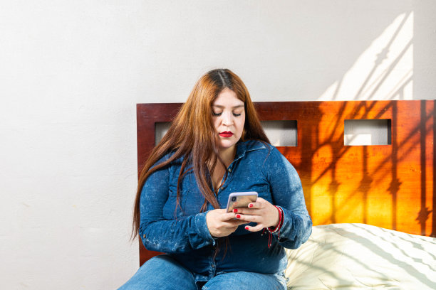 超大号的女人用手机在社交网络上发信息图片下载