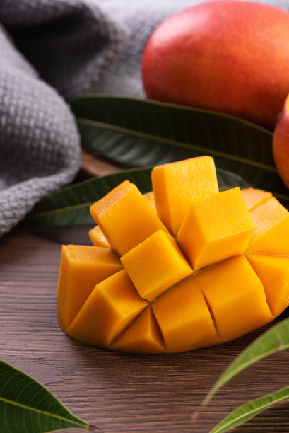芒果。新鲜的芒果水果和树叶在深色木桌子的背景。图片下载