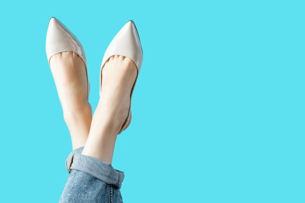 女性腿在夏天棕色的鞋子上的蓝色背景，拷贝空间。图片下载