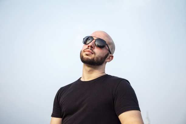 英俊的光头男模在阴影里想着成功的城市图片下载