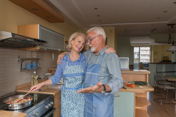 一对老夫妇喜欢在家做饭。任何时代的浪漫。图片下载