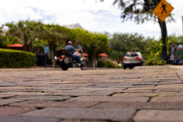 砖街，摩托车和汽车低角度图片下载