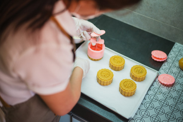在烘烤前的烤盘上，女人们正在制作自制月饼糕点的面团图片下载