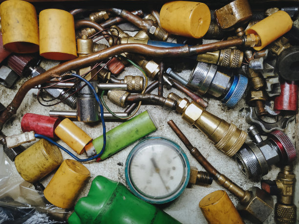 铜管、铜管、金属管、衬套、适配器、螺母、扳手等形式的锁匠和管道零件、工具和备件。制冷维修技术员的概念。图片下载