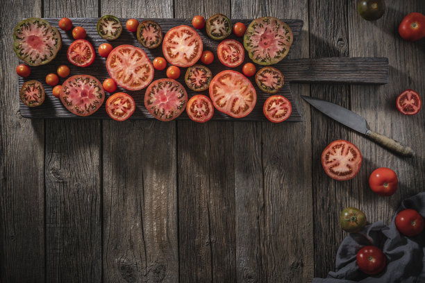 在木桌上的木板上切各种各样的西红柿图片下载
