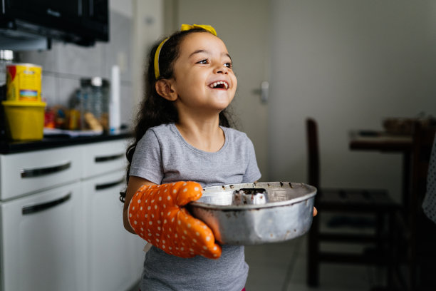 快乐的小女孩在厨房里拿着蛋糕模图片下载