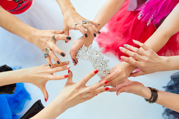 女孩们的手伸向了皇冠。谁会是女王，老板还是第一个美女。竞争与竞争的概念。图片下载