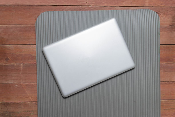 健身房瑜伽垫上的笔记本电脑。在线健身课程概念图片下载