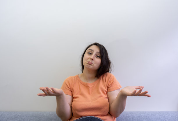 一个漂亮的年轻女人用她的手做出我不知道不知道的手势图片下载