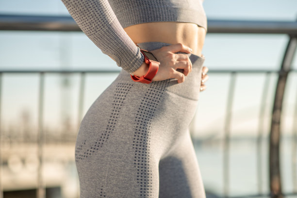 一个穿着灰色运动服的女性的特写照片，手腕上戴着一块智能手表图片下载