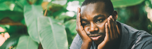不高兴的非洲人有困惑的表情，手在他的脸颊。感到无聊或沮丧的黑人男性图片下载