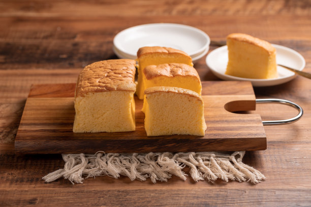 简单经典的台湾传统海绵蛋糕(台湾castella kasutera)放在砧板上的背景桌子上，靠近食材。图片下载