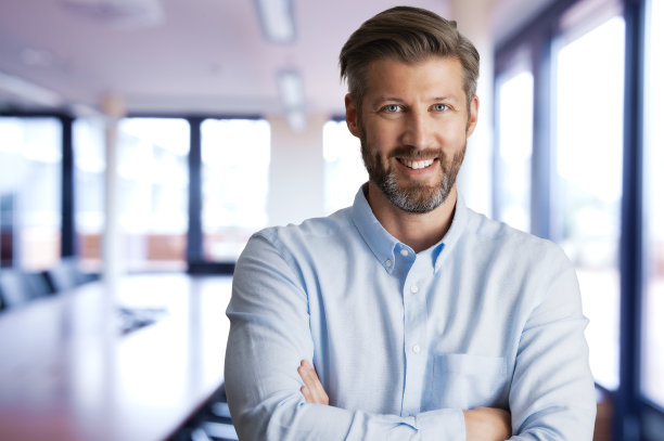 英俊的普通商人站在办公室里图片下载