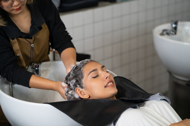 美丽的白人女性在洗发和按摩时感到放松和舒适。发廊工作室拥有发型时尚、美丽、时尚的理念。图片下载