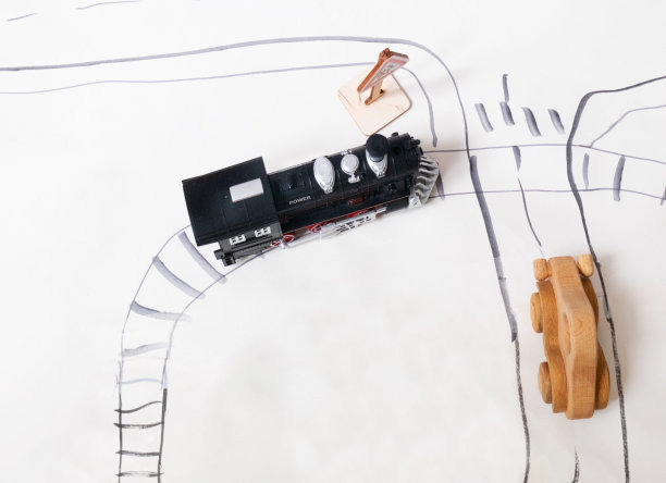 复古玩具机车和木制汽车在十字路口的道路上。图片下载