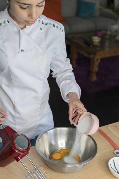 女厨师在直播节目中向粉丝们讲述如何用她的浅色戒指和制服准备蛋糕图片下载