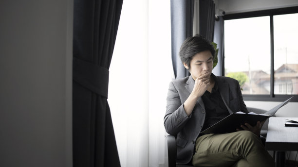 聪明的商人坐在现代的工作场所。图片下载