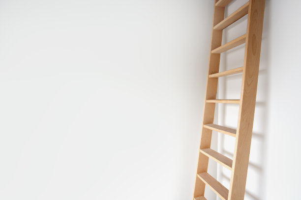 侧视图的木梯靠在现代设计的白色墙壁上，时尚的楼梯在明亮的房间里带有拷贝空间图片下载