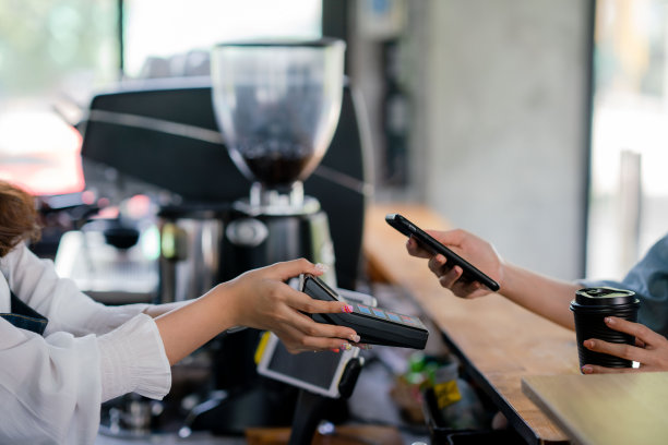 亚洲女人在咖啡馆的非接触式支付。图片下载