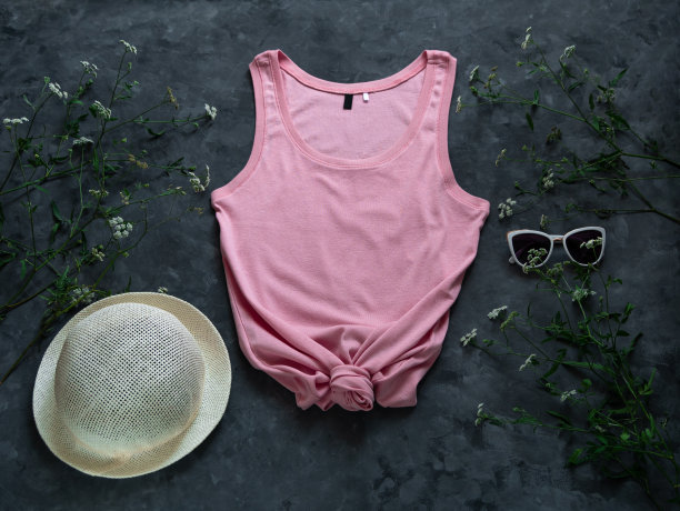 粉红色的棉背心模拟草帽在黑暗的背景。空白素色t恤模板的创意设计女性夏天图片下载