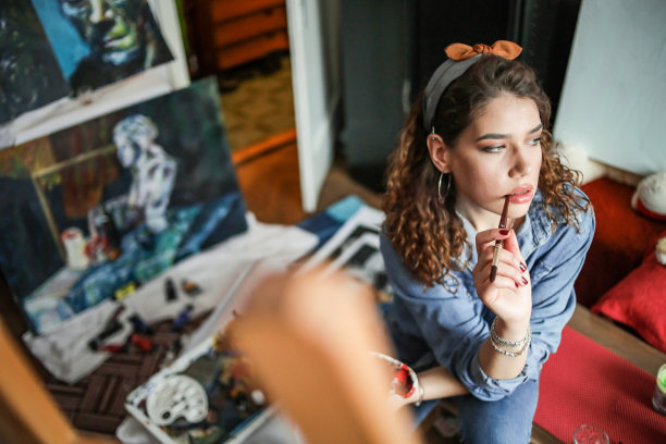 创造性的年轻艺术家在家绘画。图片下载