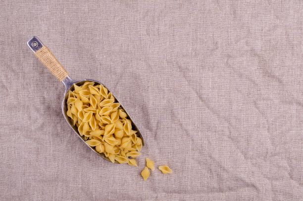 用金属勺舀干意大利面壳图片下载
