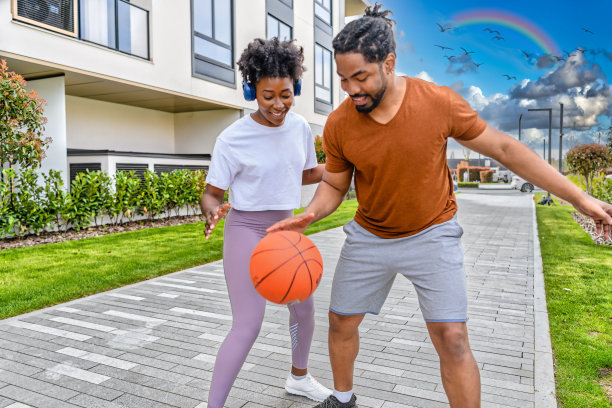 一个快乐的非裔美国人家庭正在街上玩篮球。图片下载