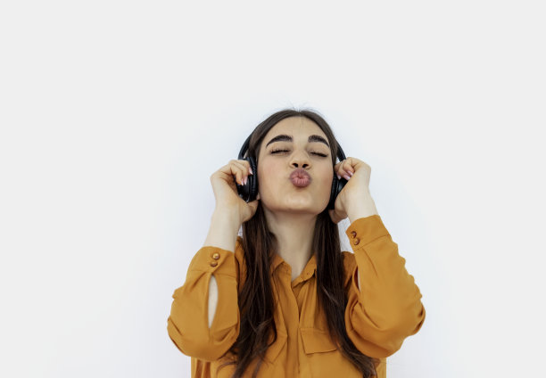 一个时髦的年轻女人唱着最喜欢的歌曲的剪影。图片下载