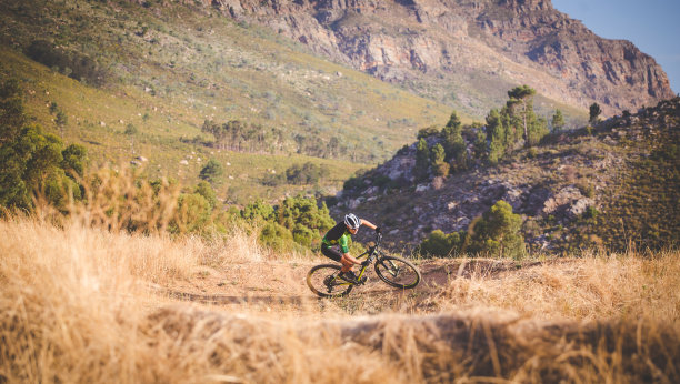 一个山地车在森林里的山地车道上加速下坡的广角视图图片下载