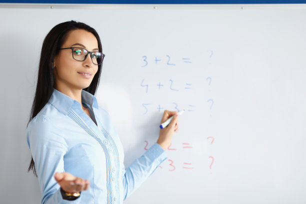 女老师站在黑板前，用公式解释信息图片下载