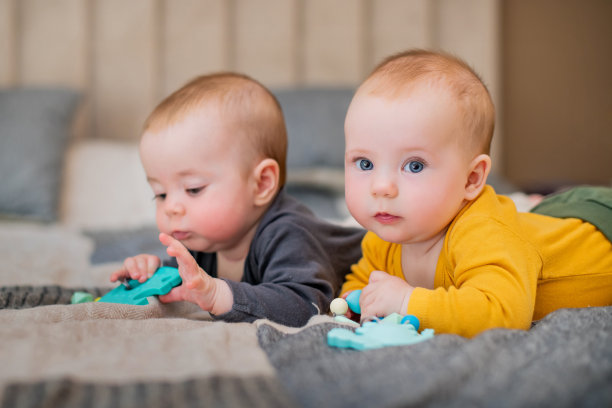 双胞胎女孩在床上躺了五个月，面带微笑图片下载