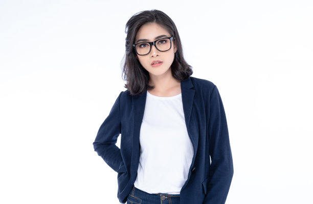 一个年轻美丽的亚洲女孩的肖像戴眼镜摆姿势，而站着看相机孤立在白色的背景。商业女性的概念。图片下载