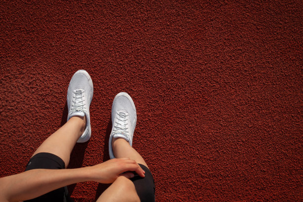 横幅女人的腿。一个女人的手在为她的球鞋系鞋带。准备运行。空间的文本。前视图。垂直图片下载