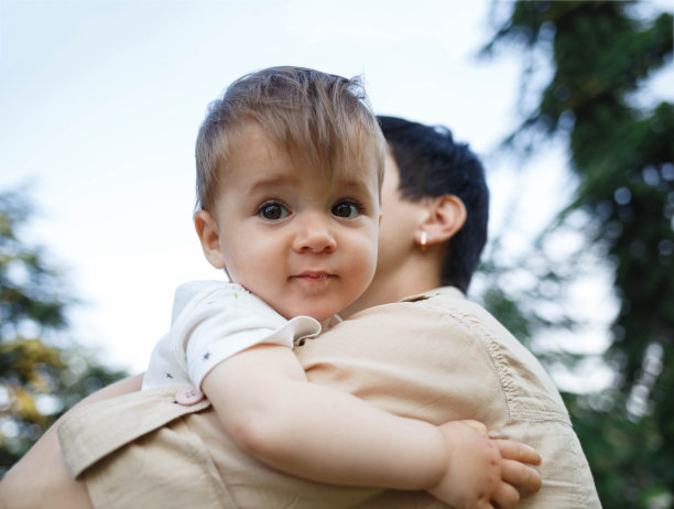 一个可爱的小男孩在妈妈怀里的肖像图片下载