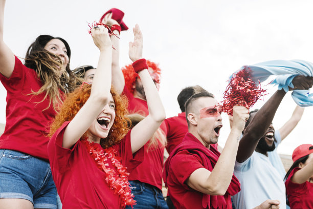 兴奋的一群多种族的朋友看足球比赛事件-红色的球迷尖叫，同时支持他们的球队-关注红发女人的脸图片下载