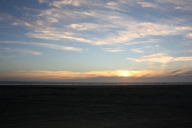 当太阳慢慢落下时，海滩图片下载