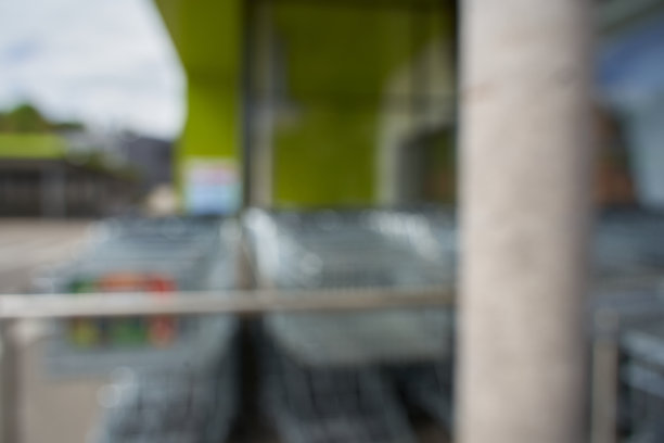 模糊的。德国一家购物中心前的两排购物车和一根灰色柱子。超市入口区域。前视图。全都失去了焦点。图片下载