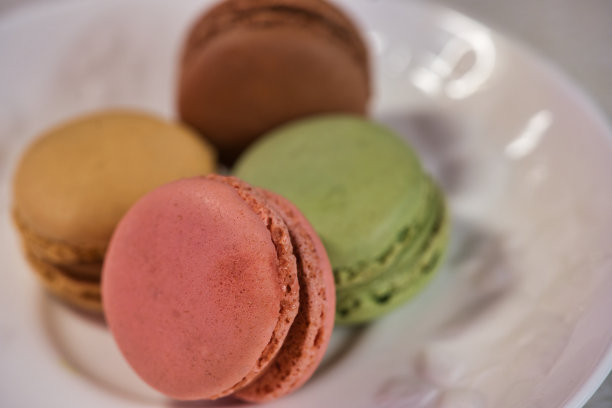 白色餐具上的彩色杏仁饼干图片下载