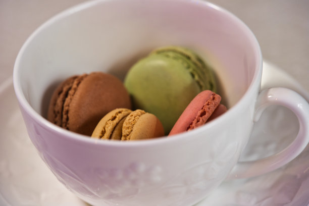 白色餐具上的彩色杏仁饼干图片下载