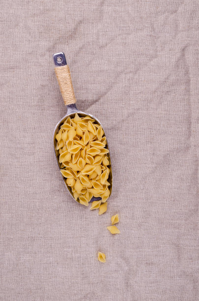 用金属勺舀干意大利面壳图片下载