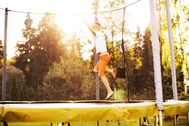 小男孩在蹦床上跳图片下载