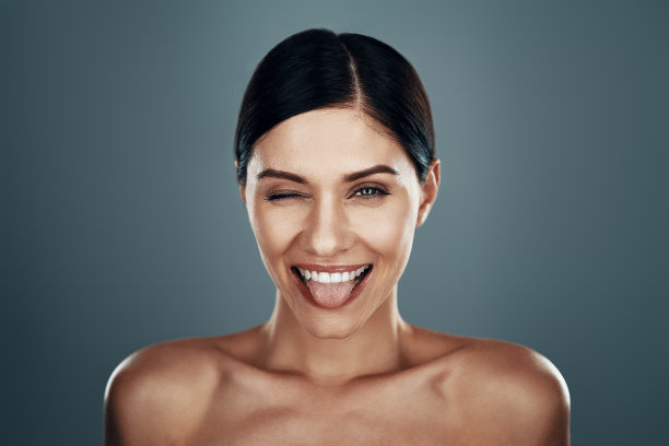 顽皮的年轻女子伸出舌头微笑图片下载