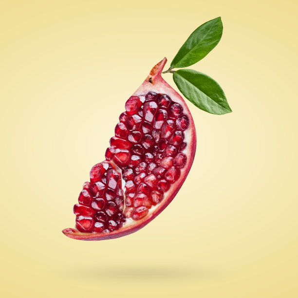 一个成熟的石榴带着种子和叶子在空中飞舞。背景以石榴果。图片下载