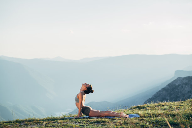 年轻女孩在日落练习瑜伽图片下载